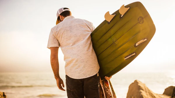 Male model holding surfboard.